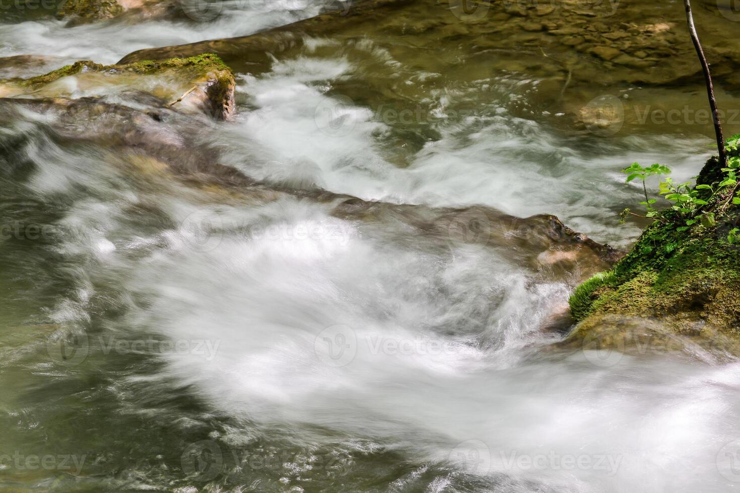 Mountain stream in the forest - long exposure and flowing water photo