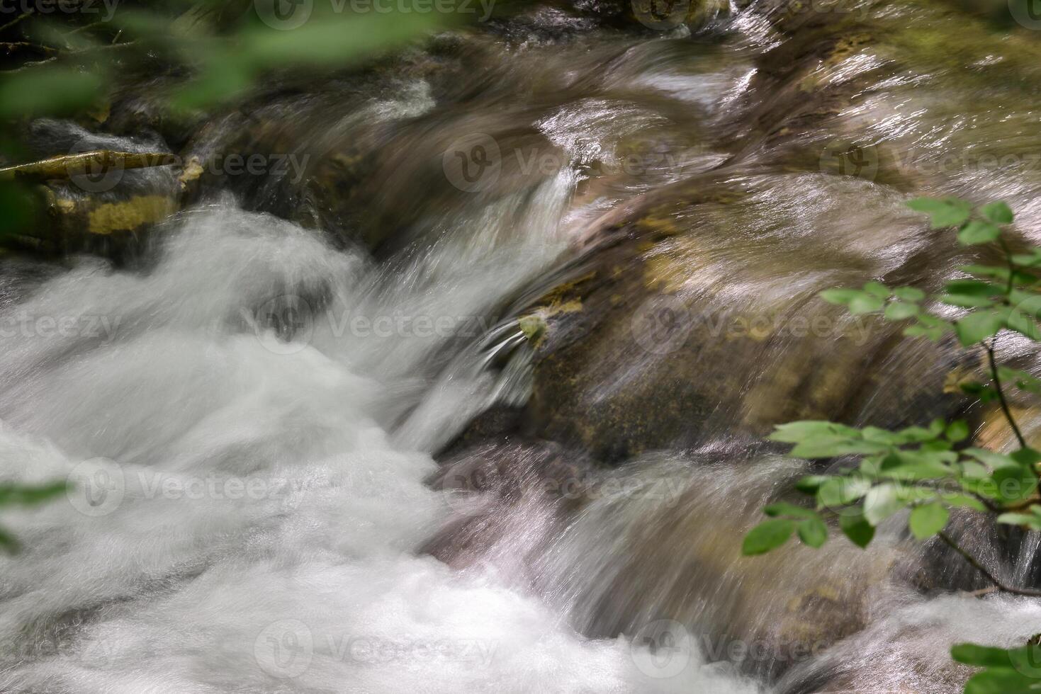 Mountain stream in the forest - long exposure and flowing water photo