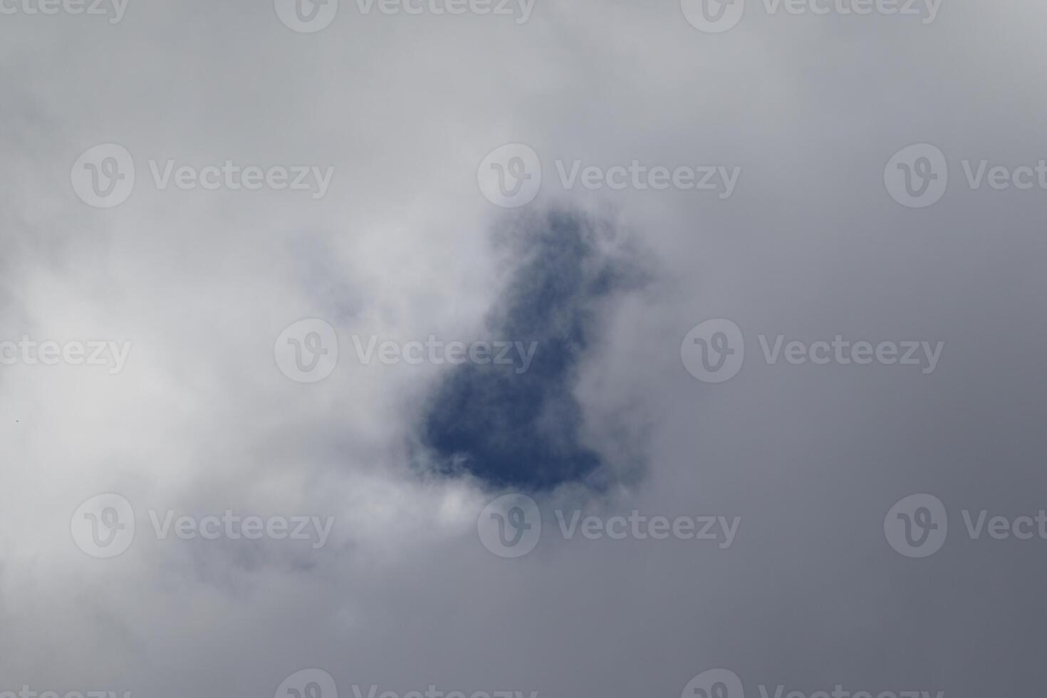 Cloudscape scenery, overcast weather above dark blue sky. Storm clouds floating in a rainy dull day with natural light. White and grey scenic environment background. Nature view. photo