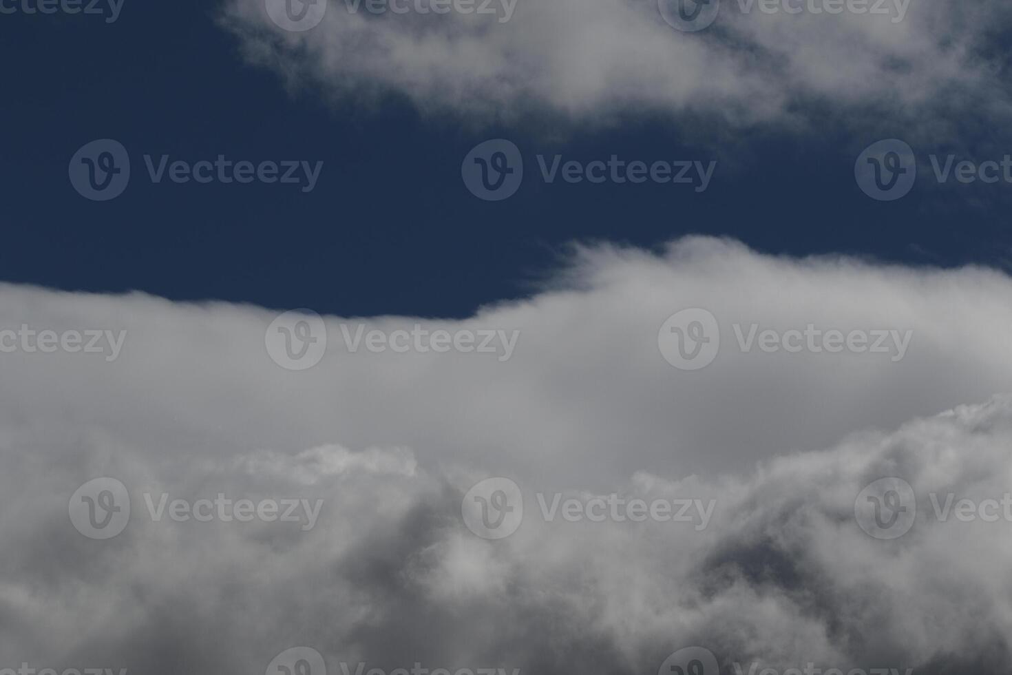Cloudscape scenery, overcast weather above dark blue sky. Storm clouds floating in a rainy dull day with natural light. White and grey scenic environment background. Nature view. photo