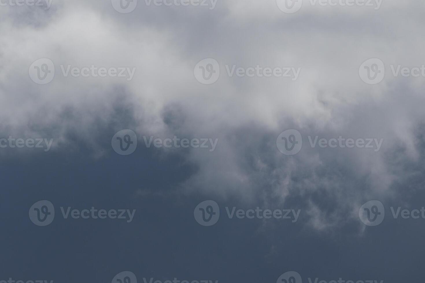 Cloudscape scenery, overcast weather above dark blue sky. Storm clouds floating in a rainy dull day with natural light. White and grey scenic environment background. Nature view. photo