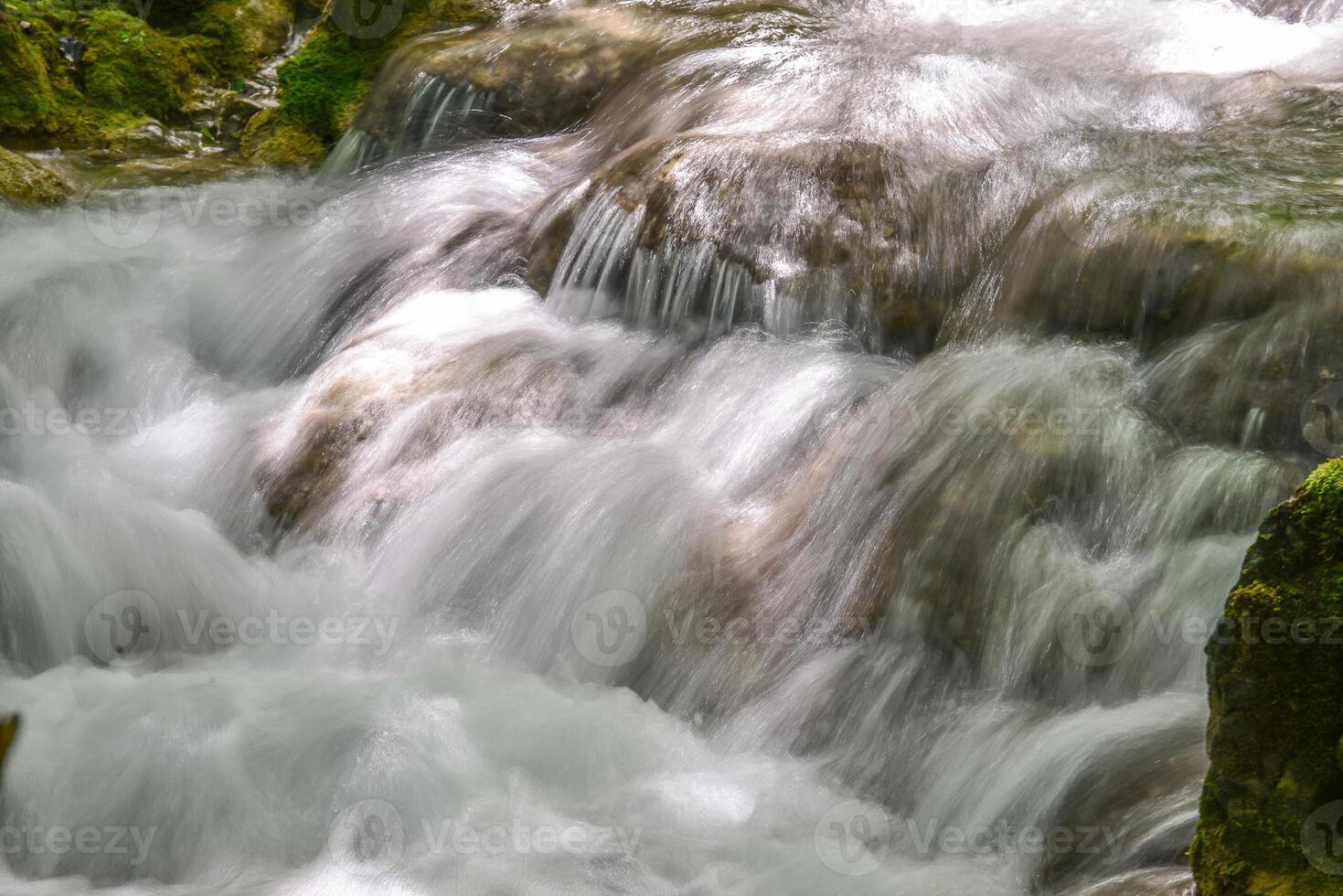 Mountain stream in the forest - long exposure and flowing water photo