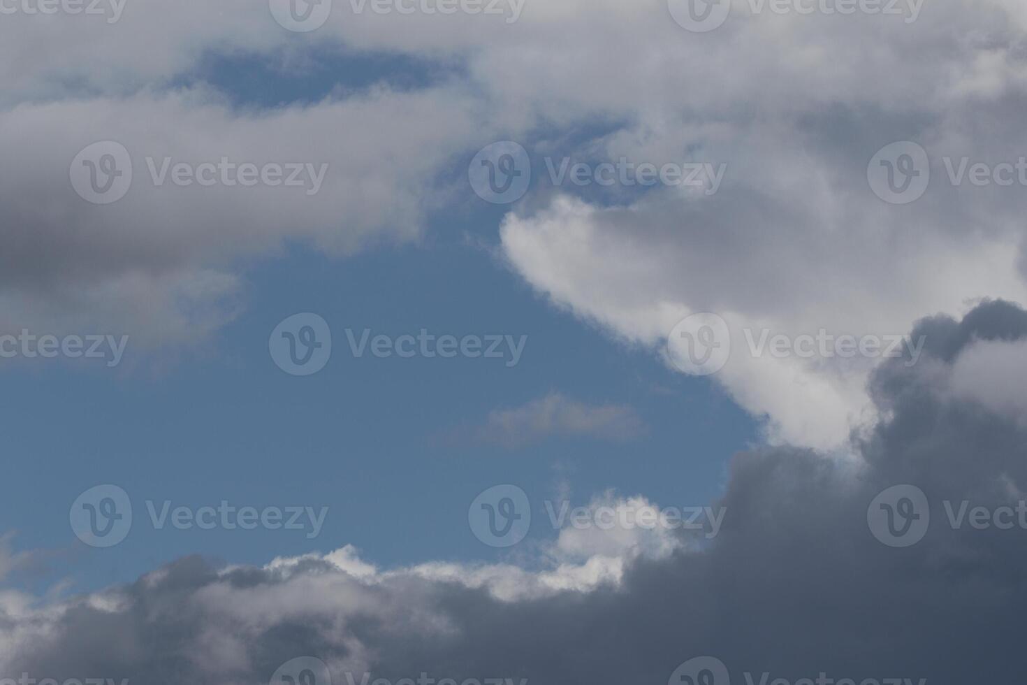 Cloudscape scenery, overcast weather above dark blue sky. Storm clouds floating in a rainy dull day with natural light. White and grey scenic environment background. Nature view. photo