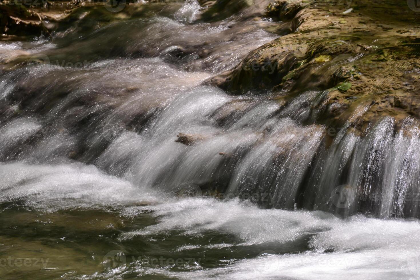 Mountain stream in the forest - long exposure and flowing water photo