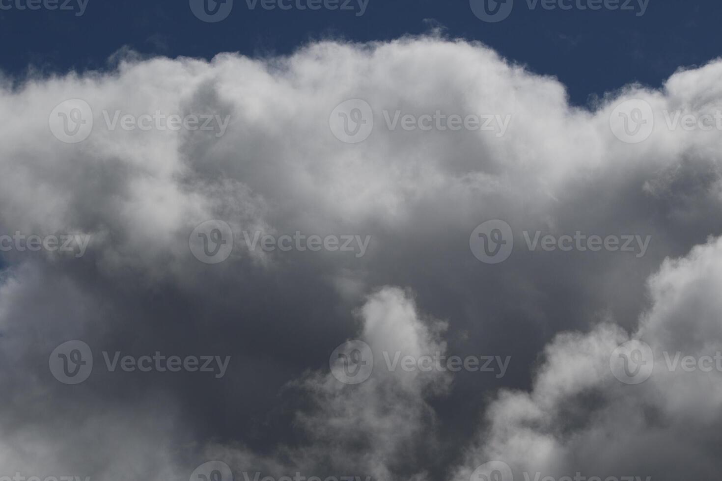 Cloudscape scenery, overcast weather above dark blue sky. Storm clouds floating in a rainy dull day with natural light. White and grey scenic environment background. Nature view. photo