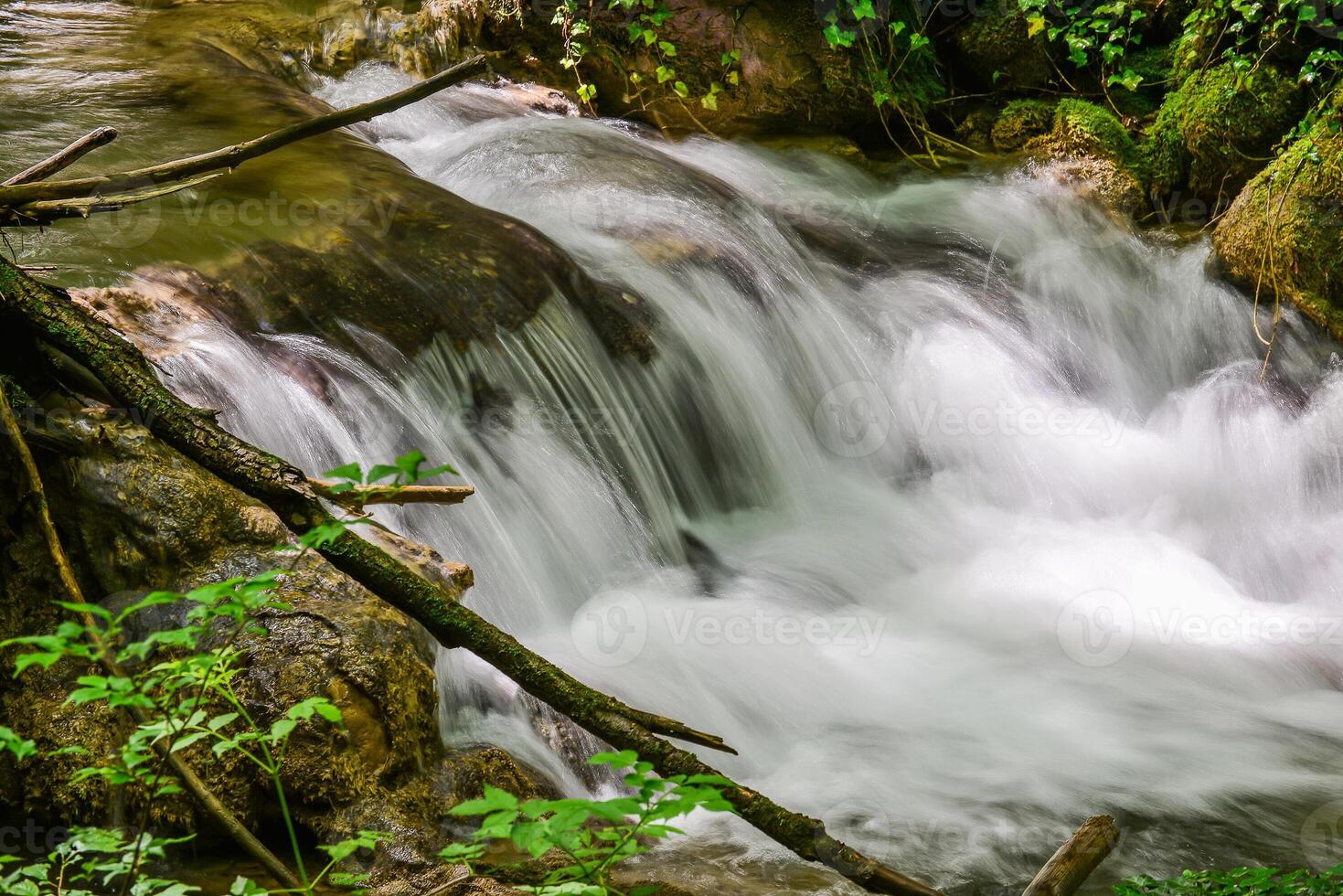 Mountain stream in the forest - long exposure and flowing water photo