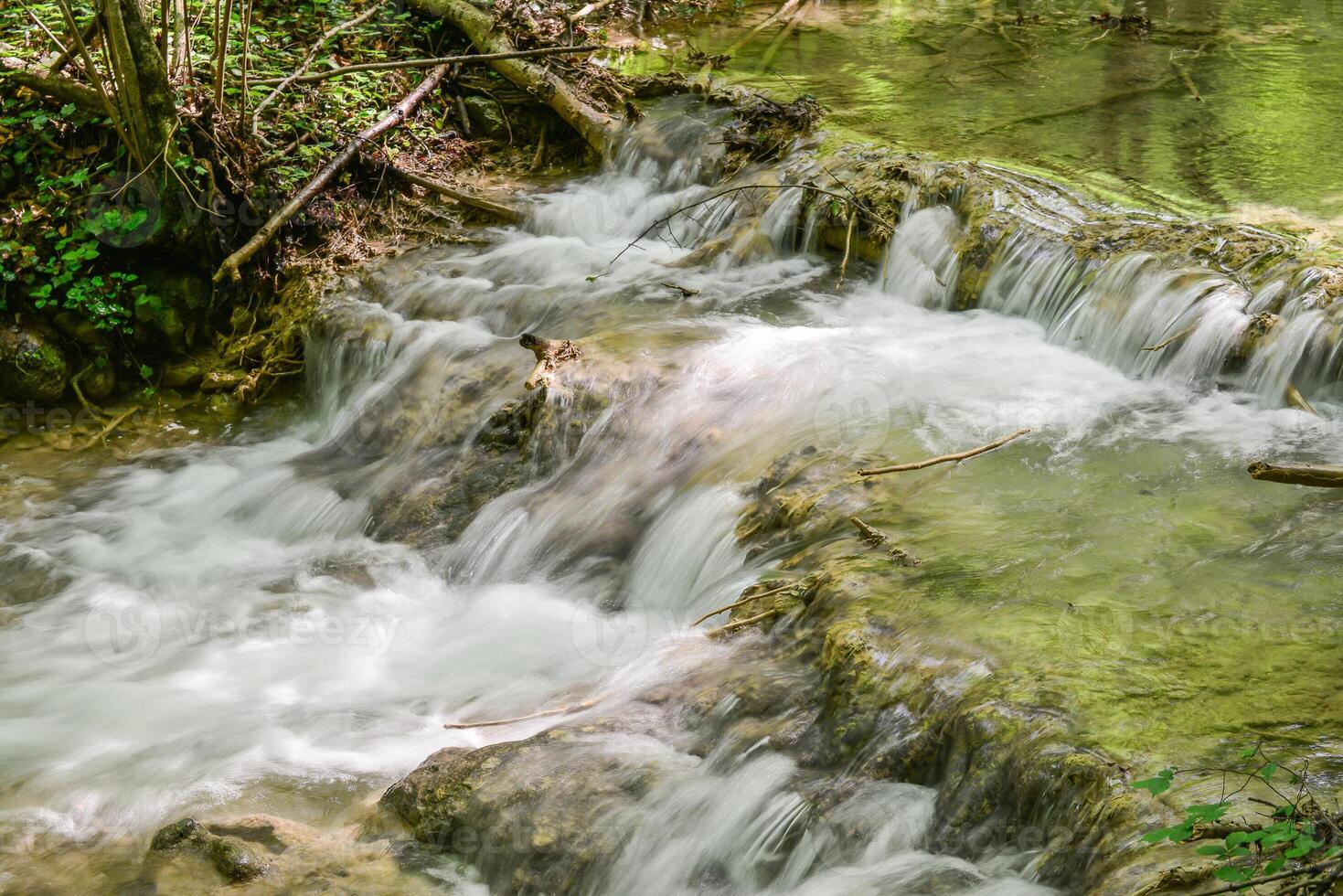 Mountain stream in the forest - long exposure and flowing water photo