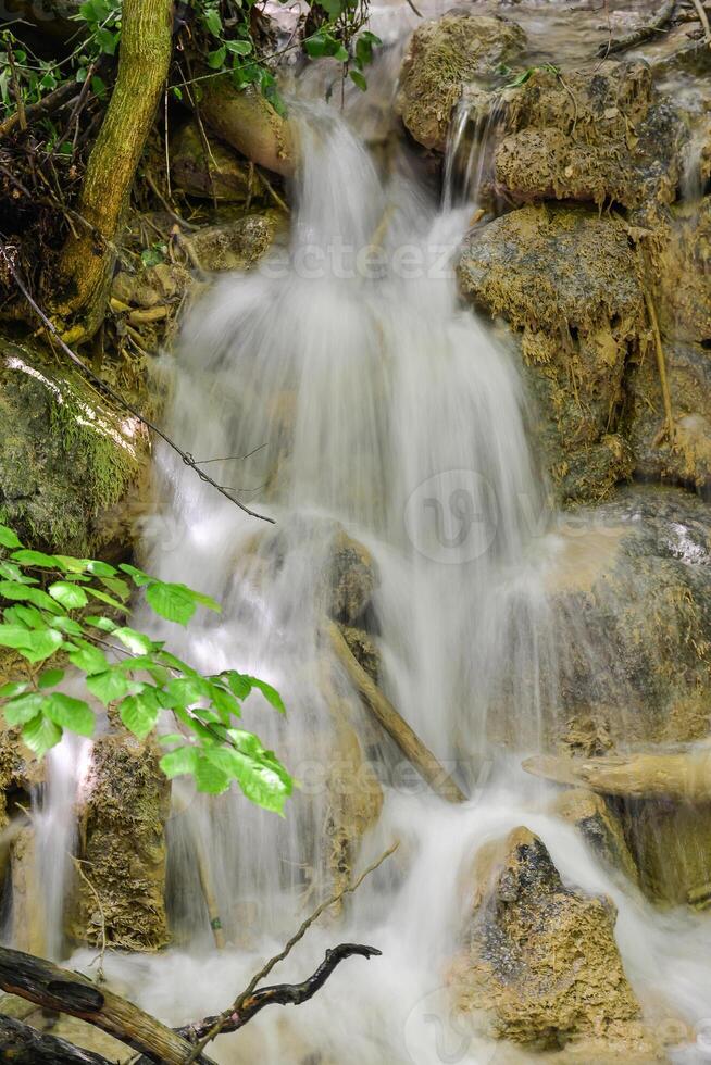 Mountain stream in the forest - long exposure and flowing water photo