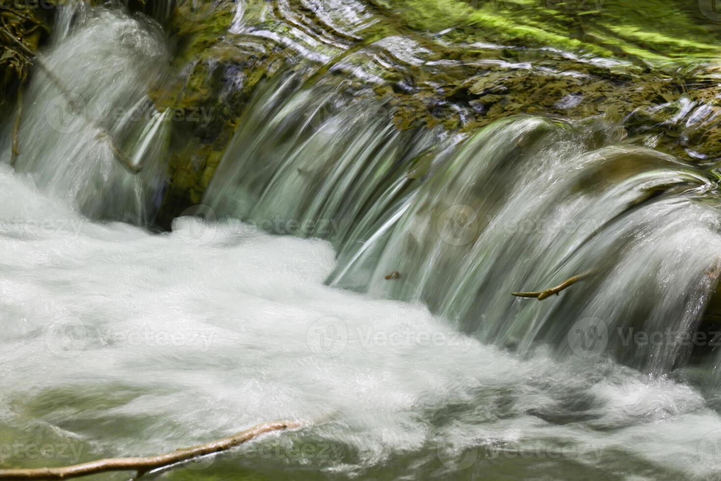 Mountain stream in the forest - long exposure and flowing water photo