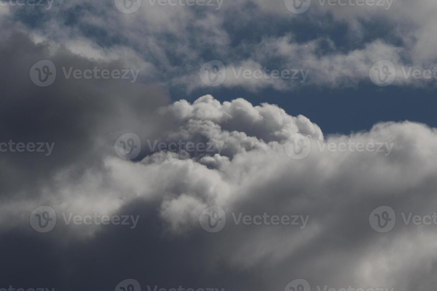 Cloudscape scenery, overcast weather above dark blue sky. Storm clouds floating in a rainy dull day with natural light. White and grey scenic environment background. Nature view. photo