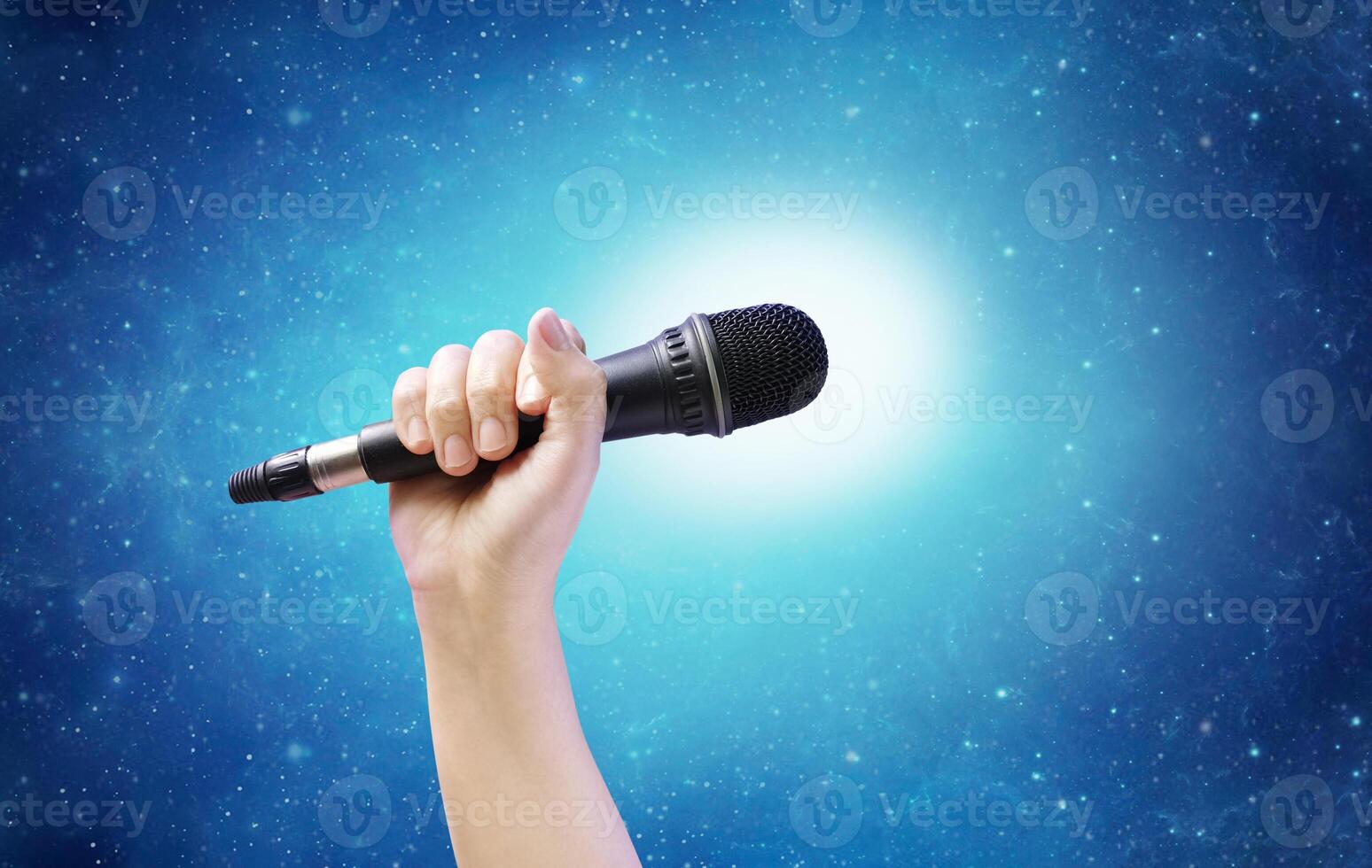 hand holding microphone with stars background photo