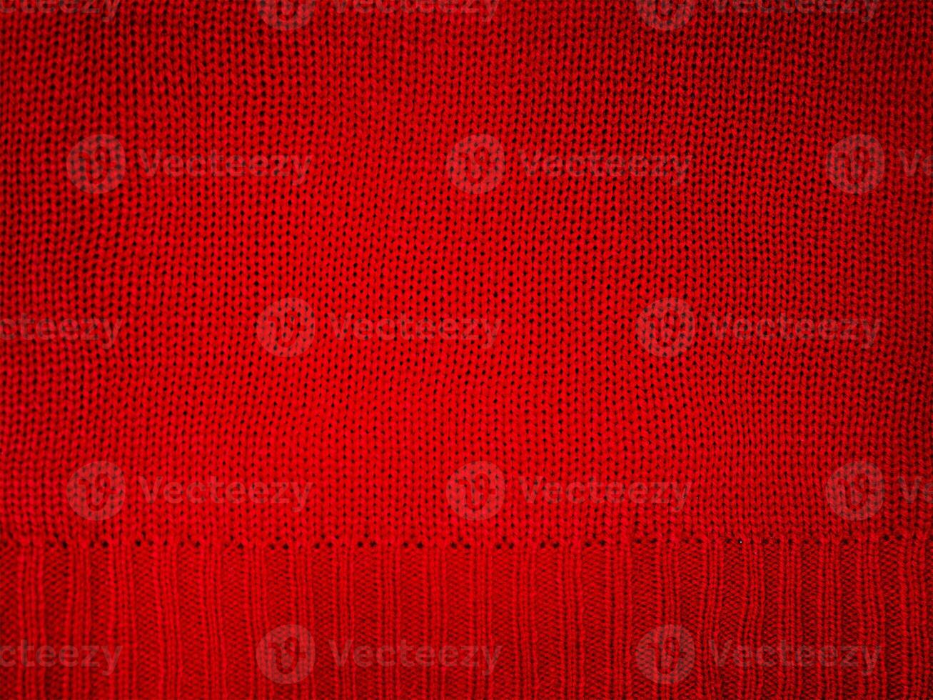 Knitted fabric red macro photo. Element of part of knitted clothes, sweater. photo