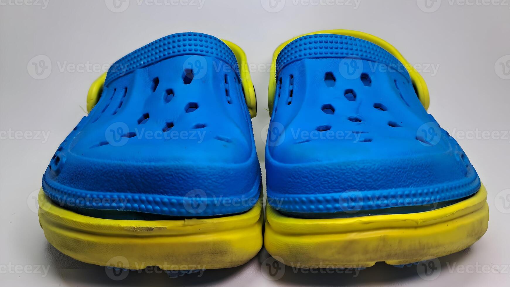 a pair of blue and yellow sandals with holes photo