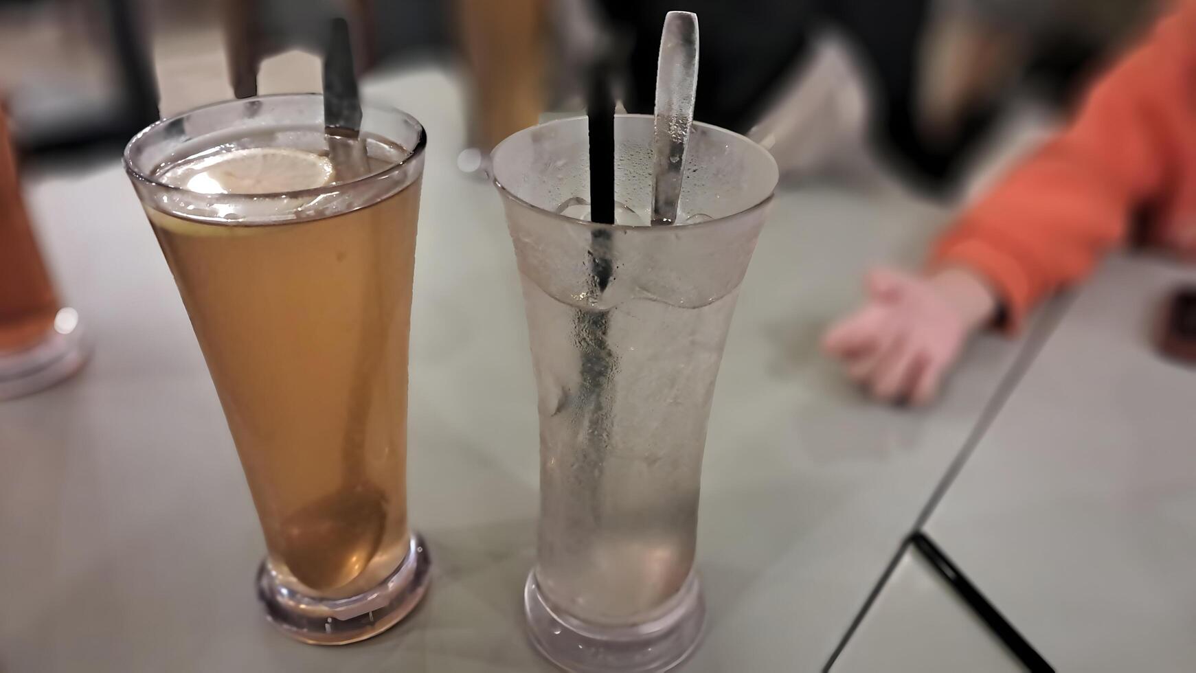 two drinks sitting on a table with a child sitting in the background photo