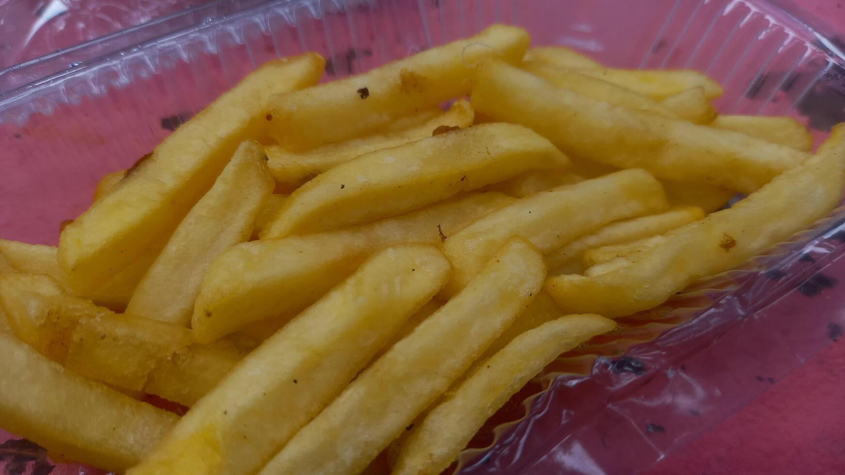 un el plastico envase lleno con francés papas fritas foto