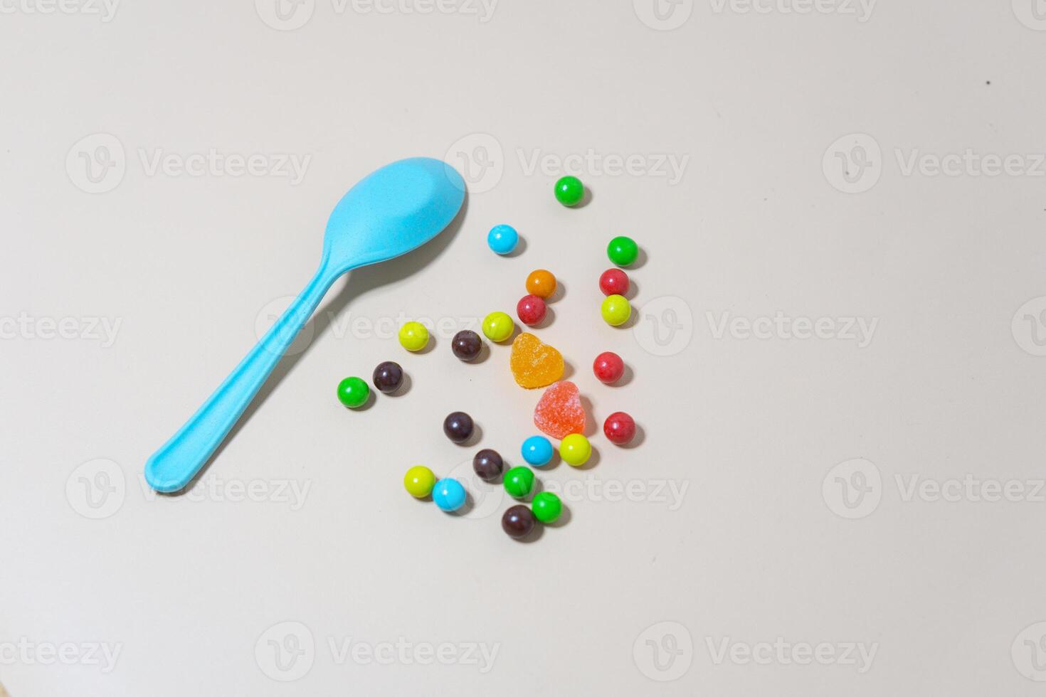 Heart shaped Candy and multi colored marble candy with spoon on Isolated on White Background. photo