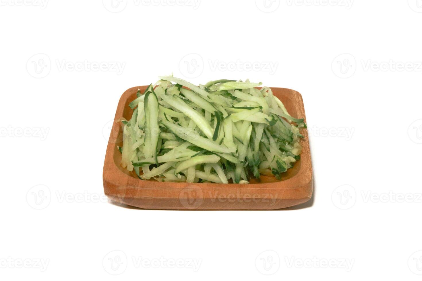 Grated cucumber in a bowl on white background. Healthy vegetarian ingredients photo