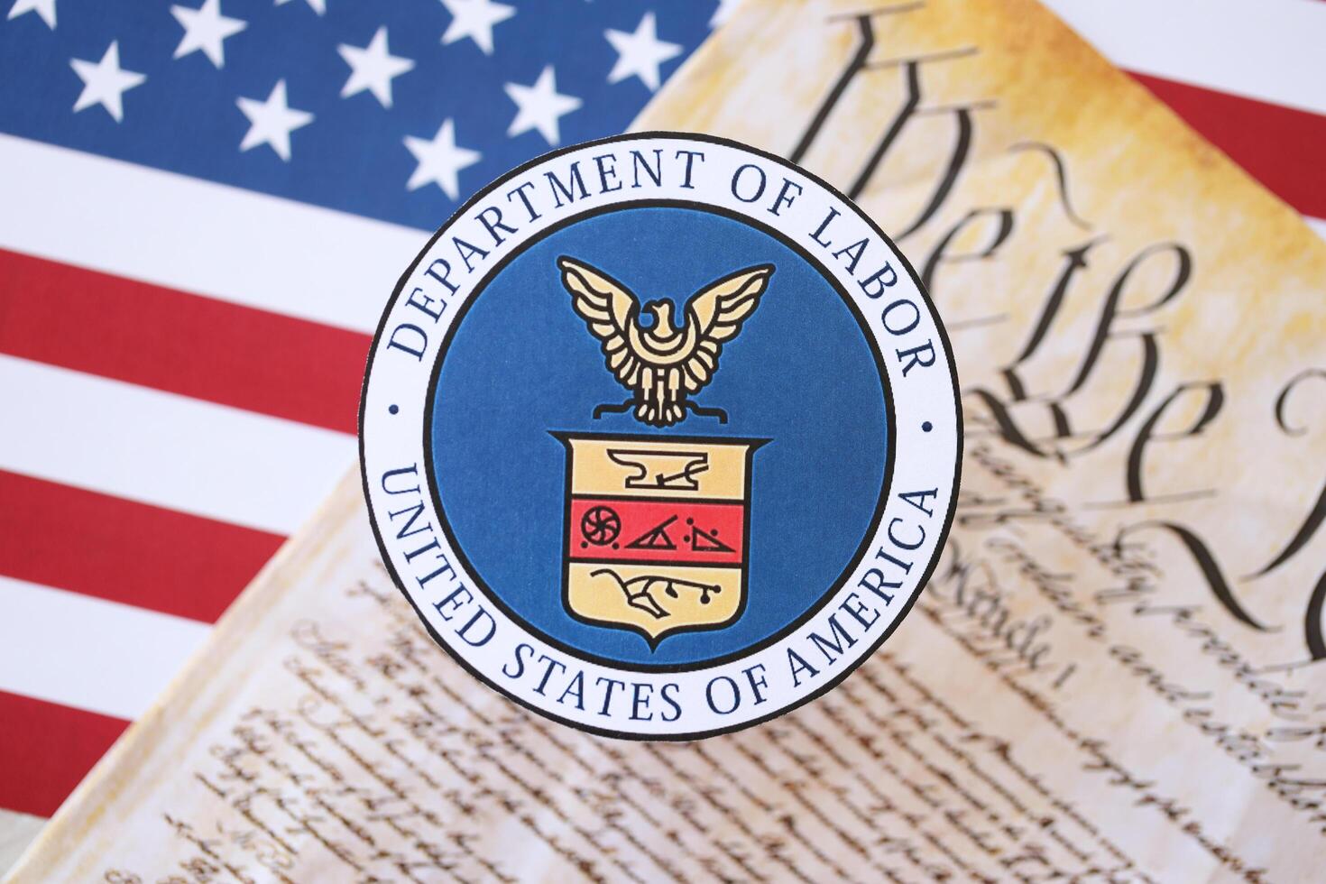 KYIV, UKRAINE - MARCH 9, 2024 US Department of Labor seal with United States Constitution on flag photo