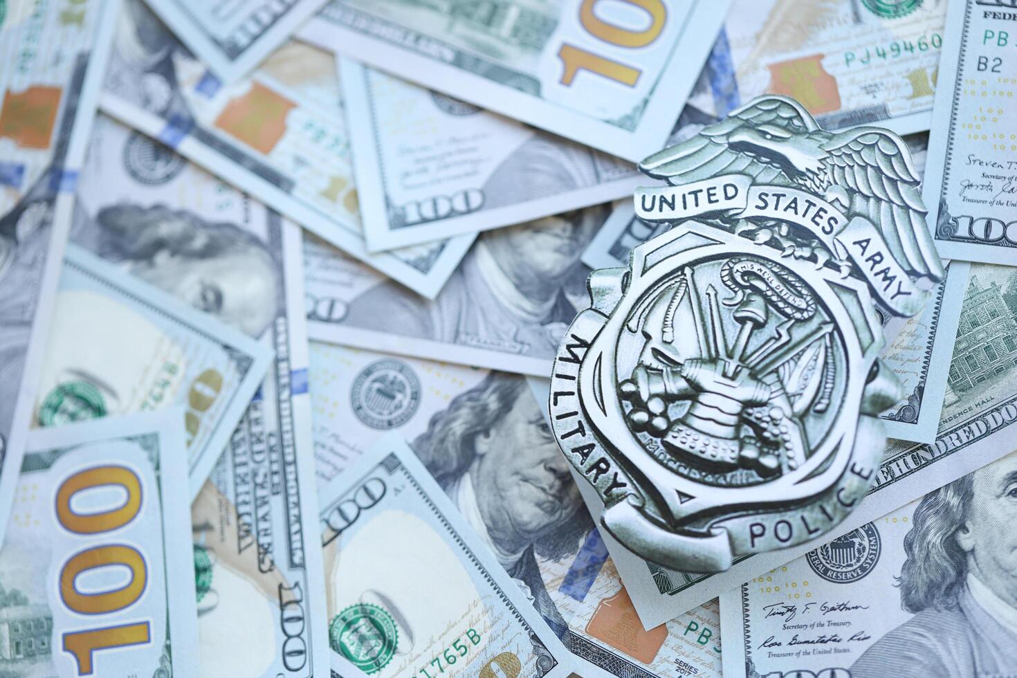KYIV, UKRAINE - MARCH 9, 2024 US Army Military Police badge on many US hundred dollar bills photo