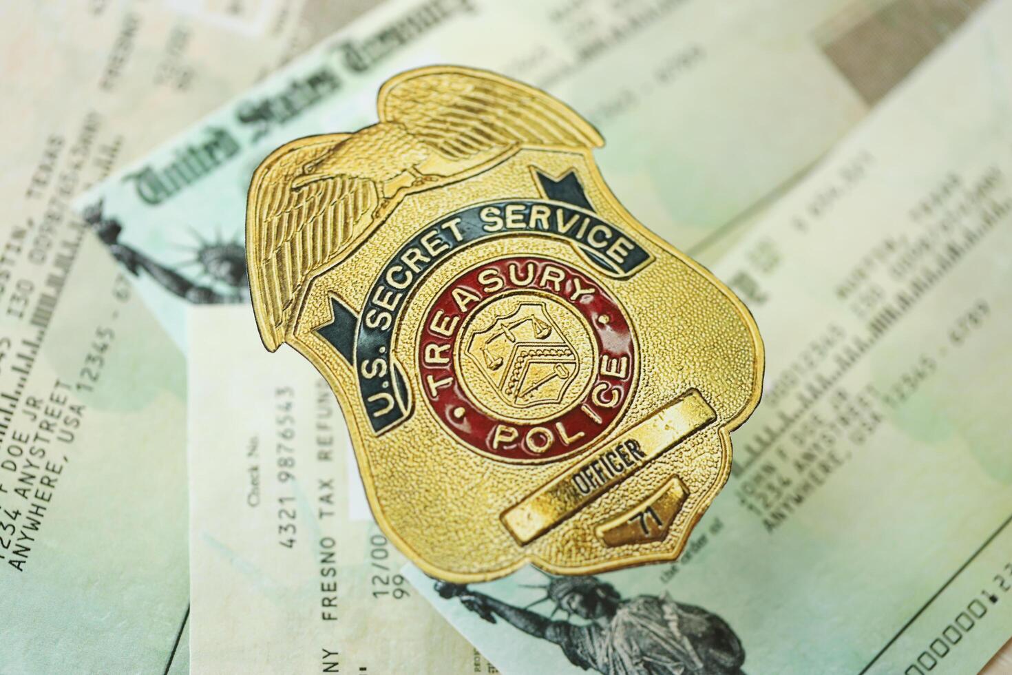 KYIV, UKRAINE - MARCH 9, 2024 US Treasury Police Secret Service Officer badge on United States Treasury refund checks photo