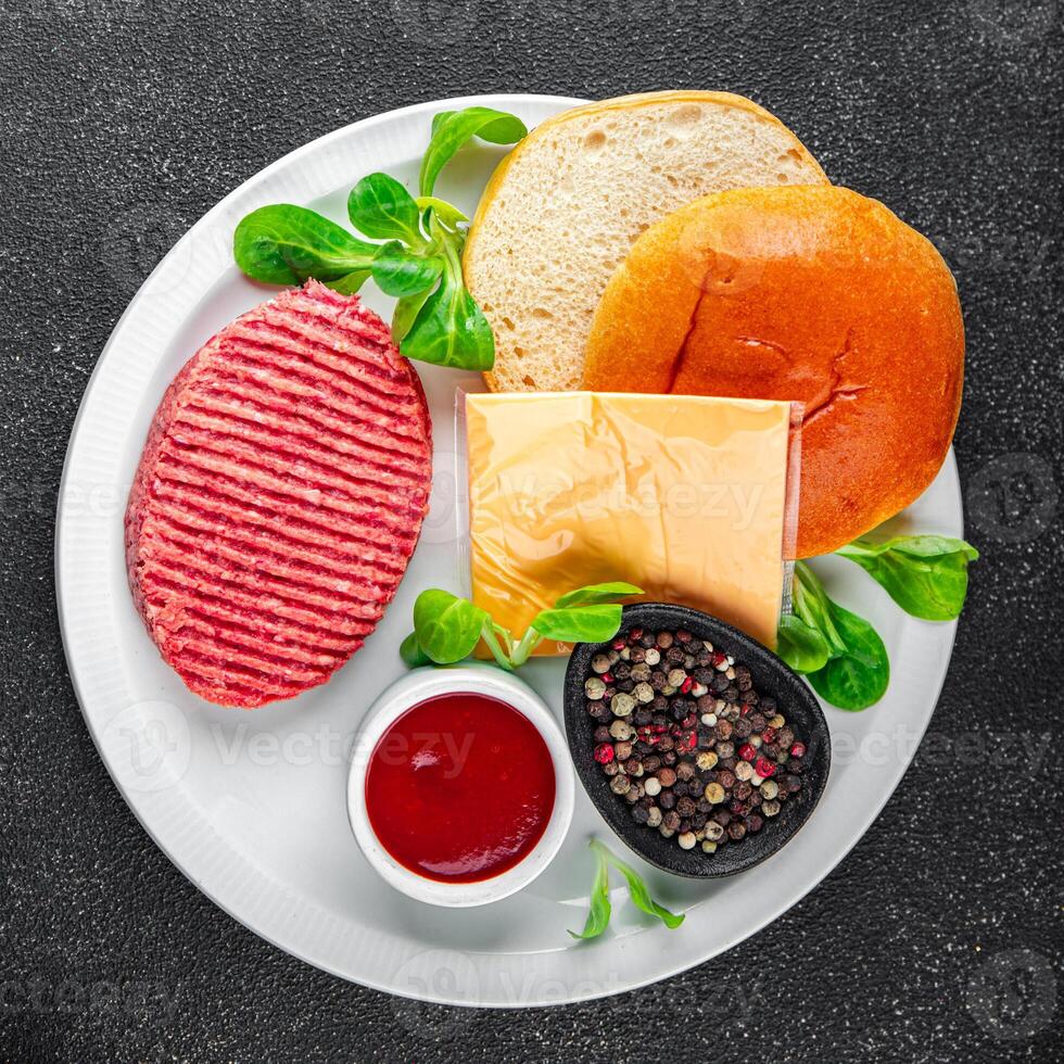 hamburguesa conjunto crudo chuleta, bollo, queso, tomate salsa, verduras Fresco Cocinando aperitivo comida comida bocadillo en el mesa Copiar espacio comida antecedentes rústico foto