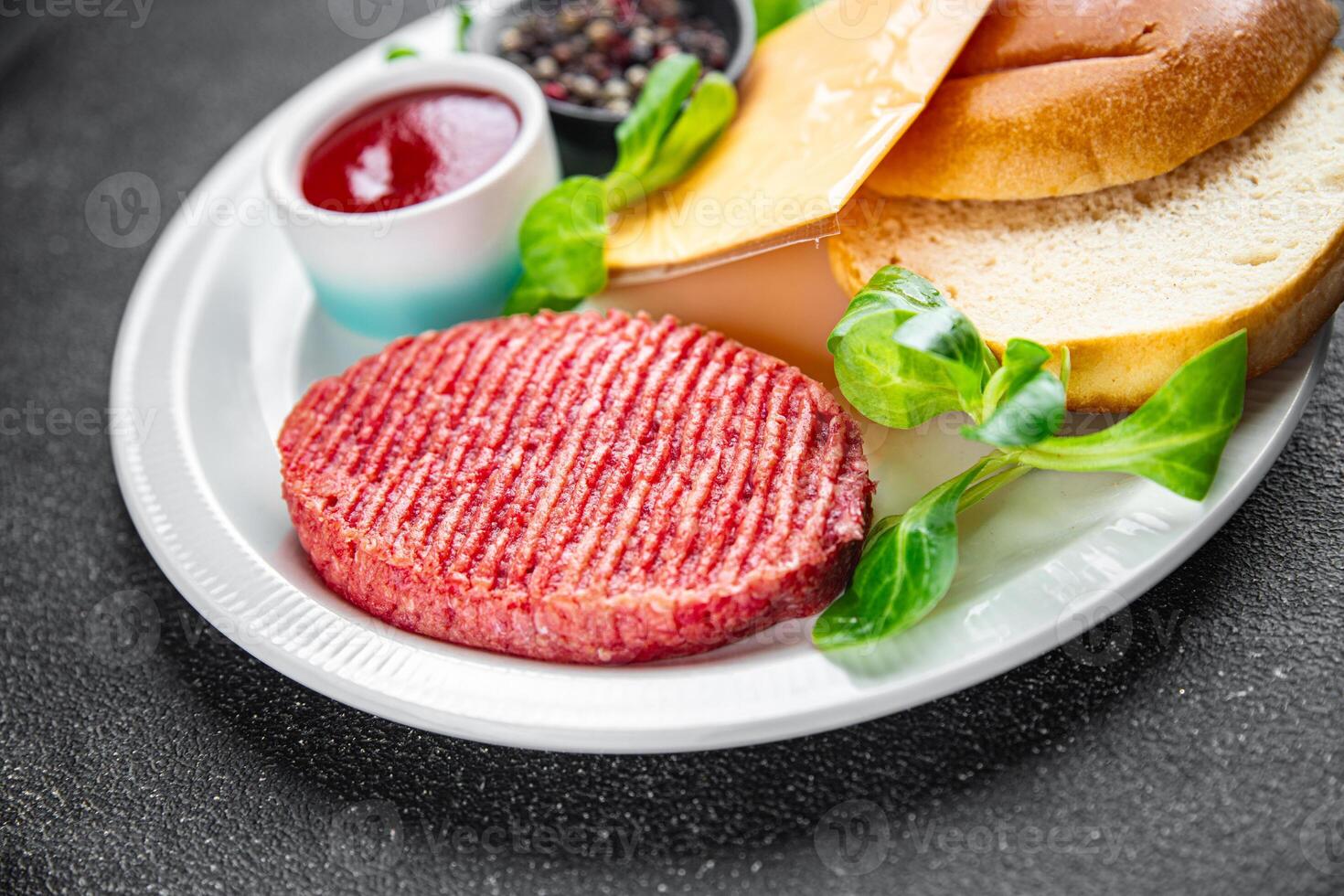 hamburguesa conjunto crudo chuleta, bollo, queso, tomate salsa, verduras Fresco Cocinando aperitivo comida comida bocadillo en el mesa Copiar espacio comida antecedentes rústico foto