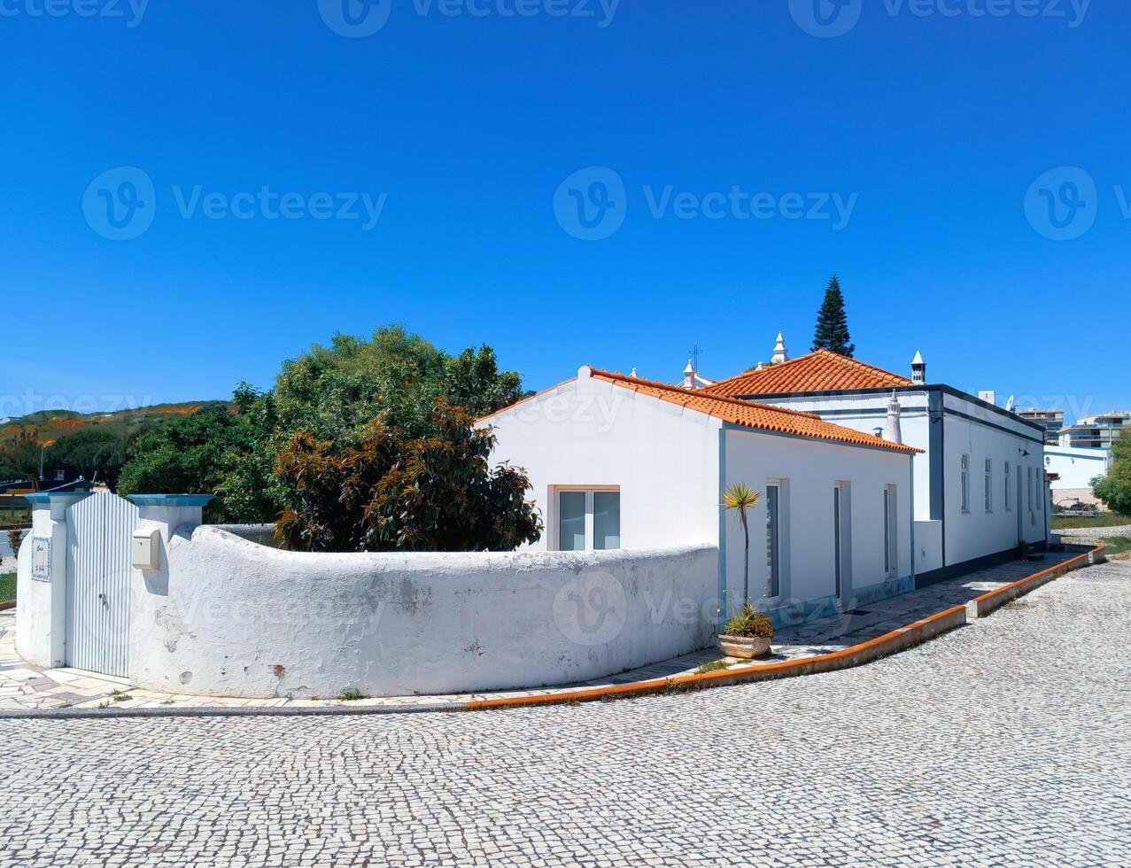 un blanco casa con un rojo embaldosado techo situado en un Mediterráneo región. foto