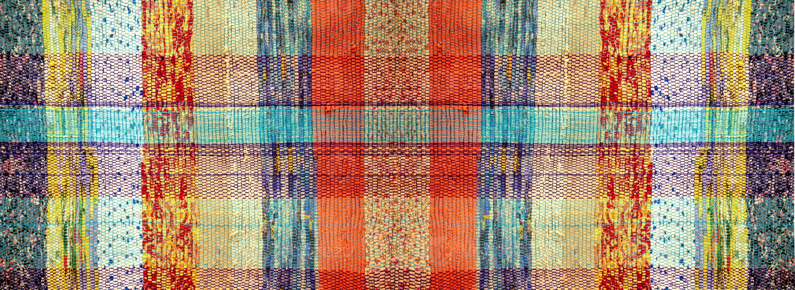 antiguo hecho a mano llano alfombra. el textura de un antiguo alfombra hecho de multicolor tiras de tela foto