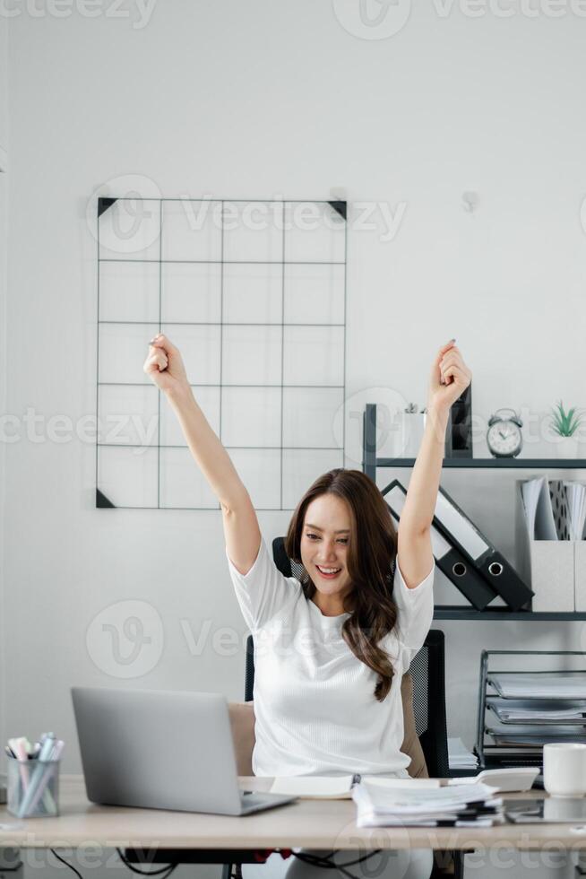 A woman is celebrating with her hands raised in the air photo