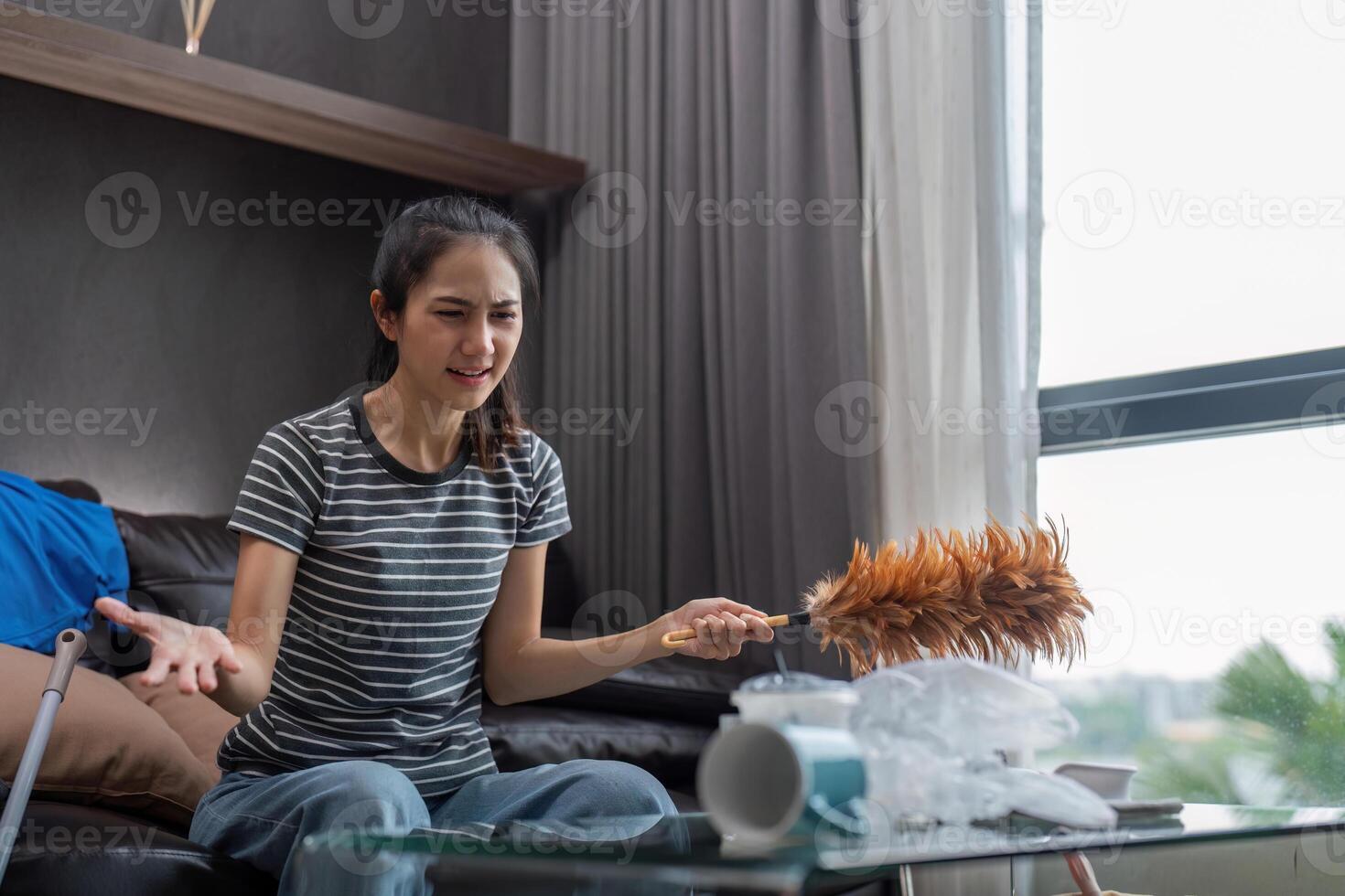 Tired young woman asian in the living room with cleaning products and equipment, housekeeper or overwhelmed girl with housework, stress cleaning, Housework concept photo