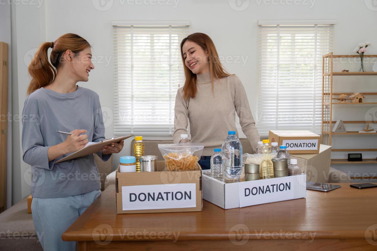 Donation and two woman volunteer asian of happy packing food in box at home. Charity photo
