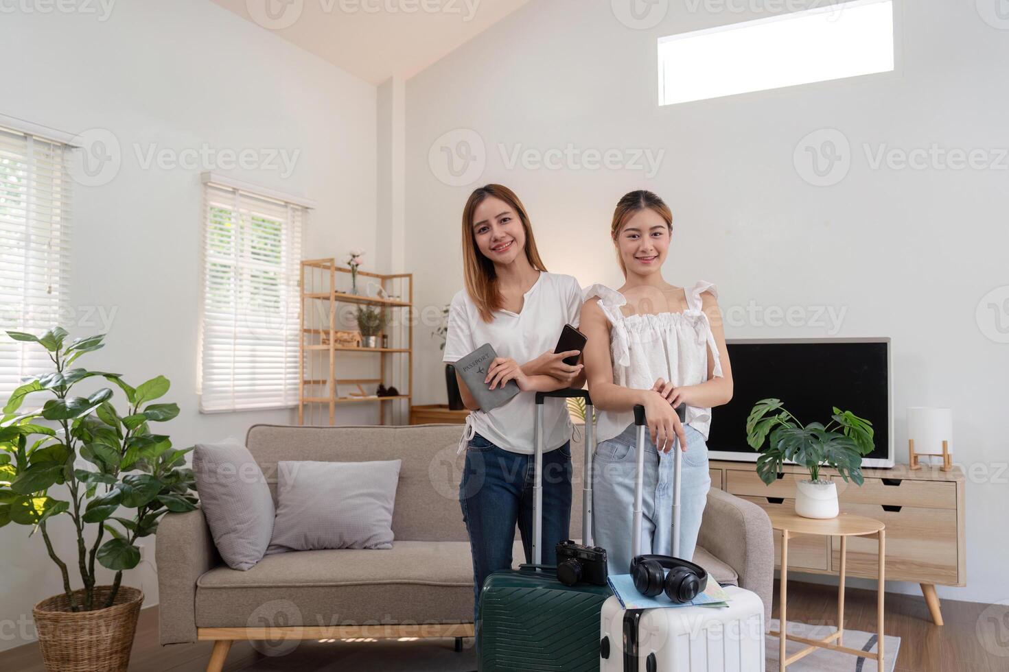 Friends and travel. Two asian young woman friends packing a travel bag before going on holiday photo