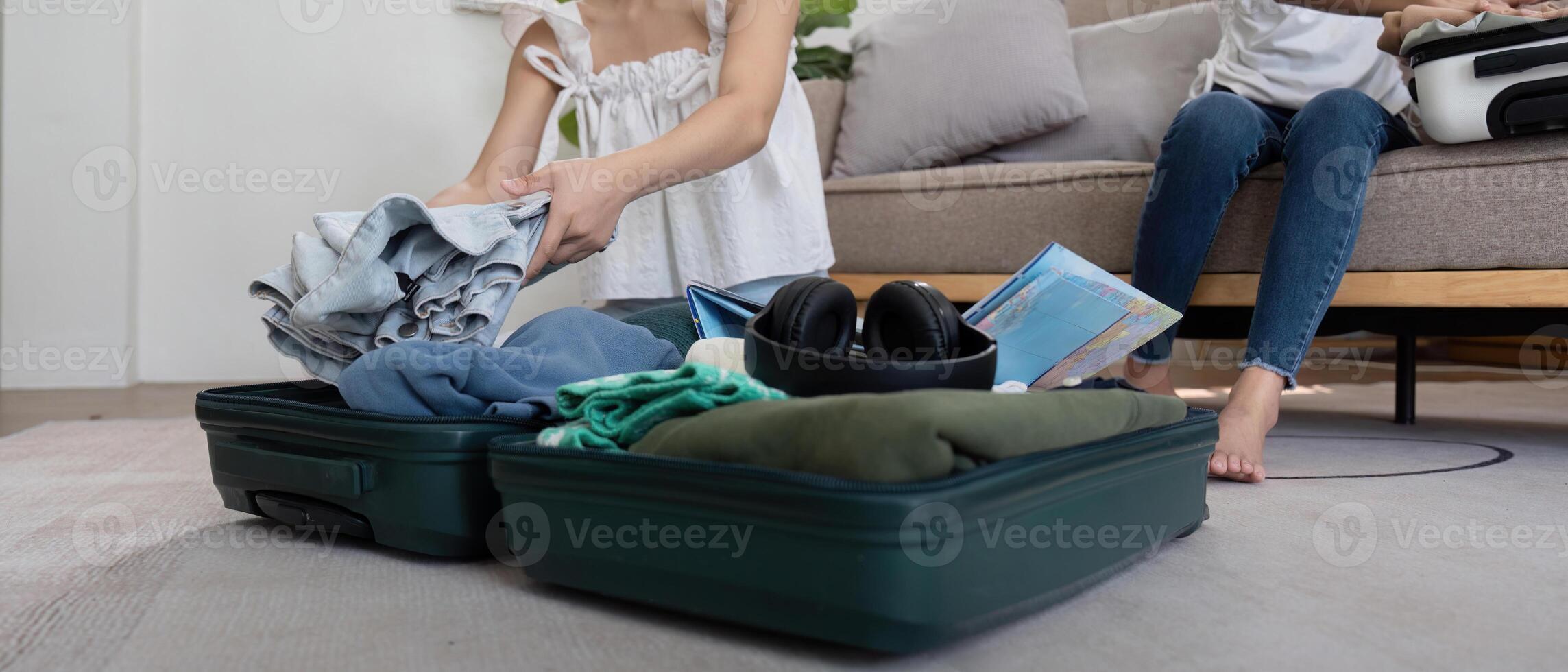 amigos y viajar. dos asiático joven mujer amigos embalaje un viaje bolso antes de yendo en Días festivos foto