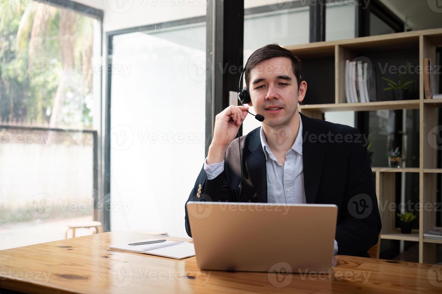 Male customer support phone operator with headset working in call center. sale agent working in office photo