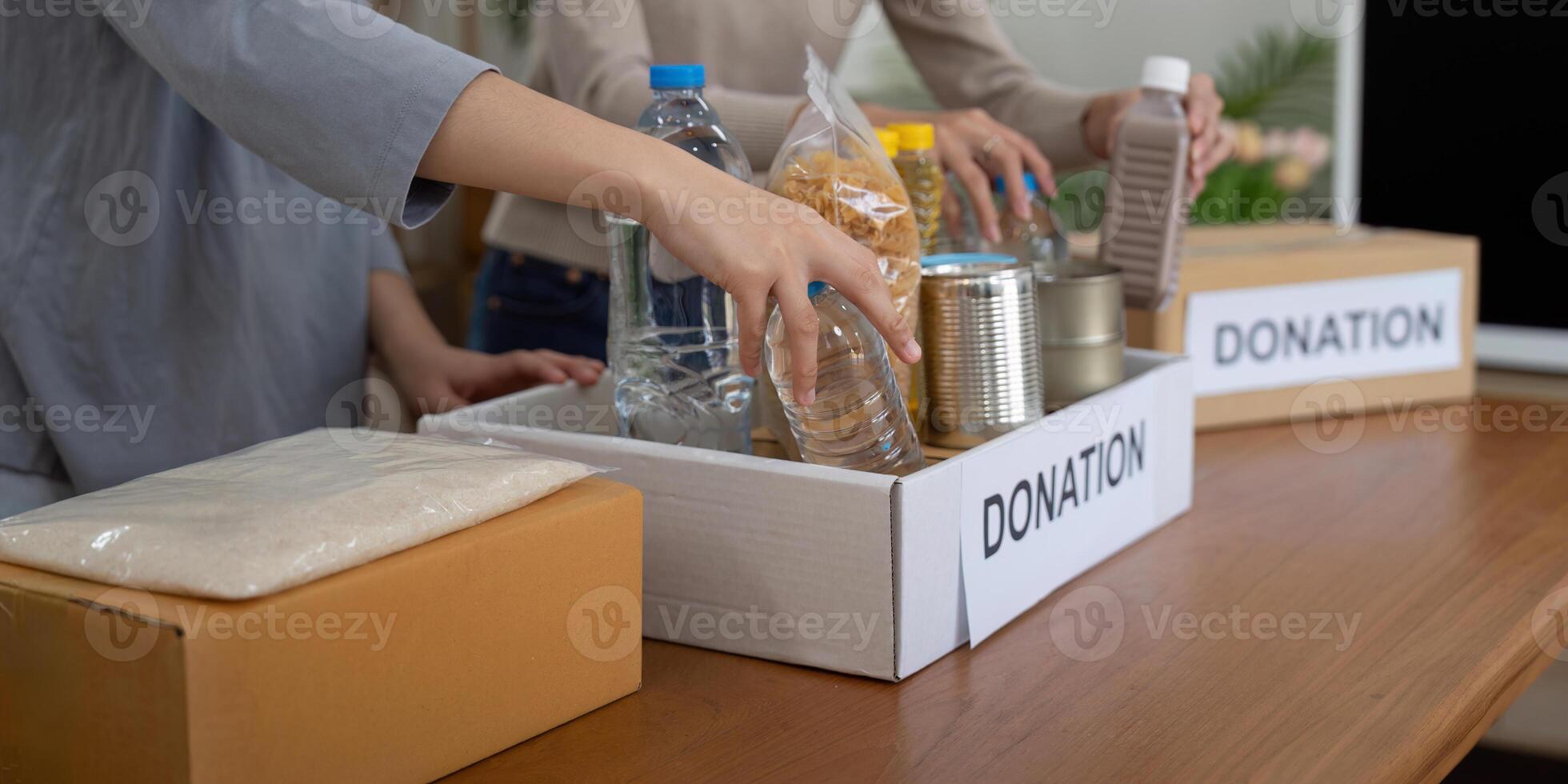 voluntario preparando gratis productos alimenticios raciones para pobre gente. caridad dos mujer de el comunidad trabajo juntos. concepto de dando y humanitario ayuda foto