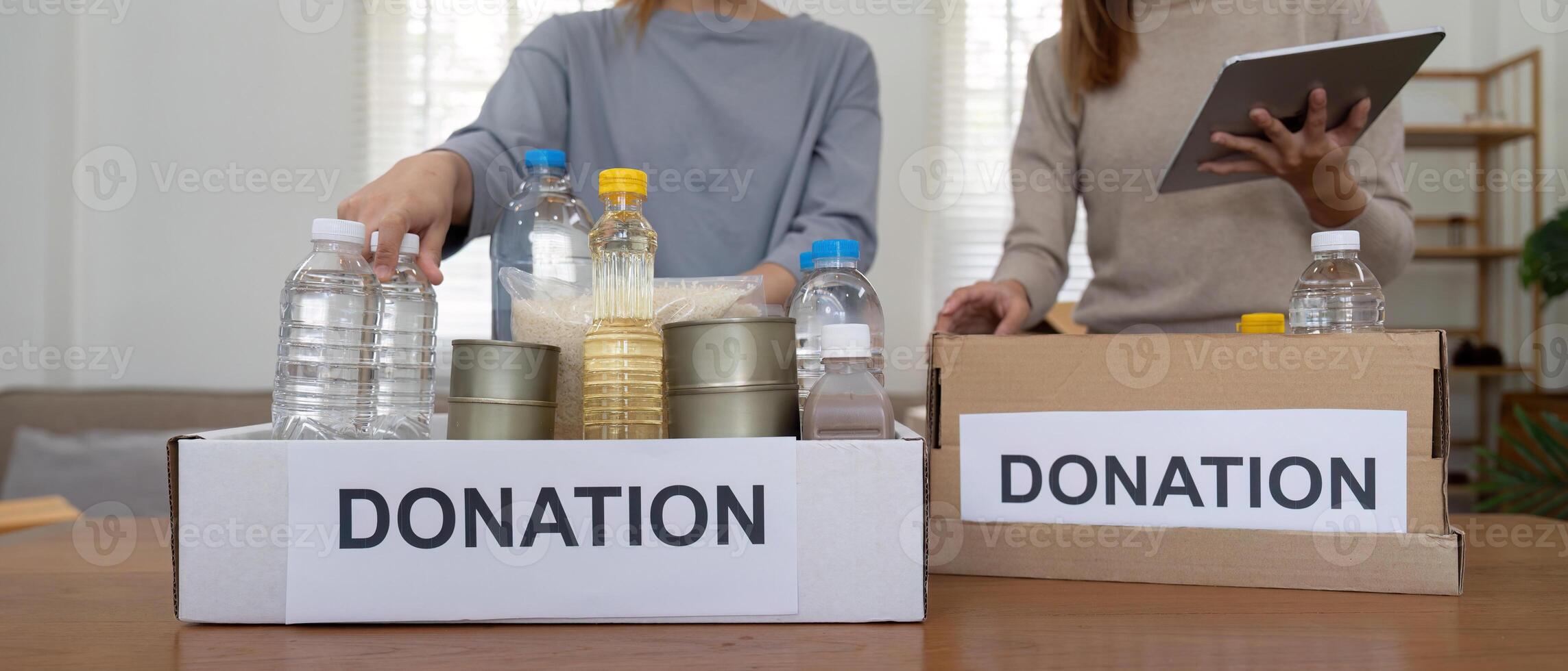 Volunteer preparing free foodstuff rations for poor people. Charity two woman of the community work together. concept of giving and humanitarian aid photo