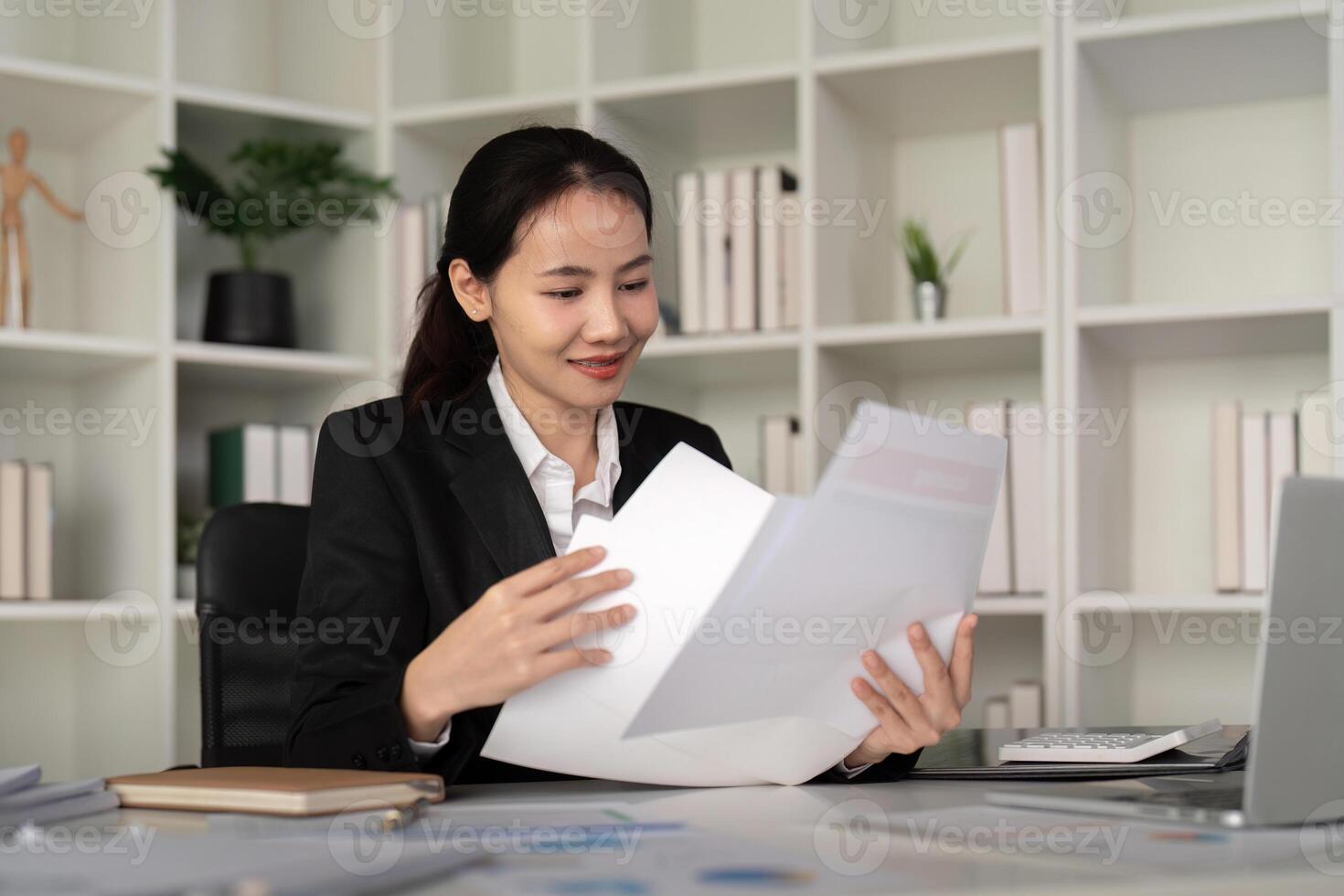 Young business woman asian or employee accounting bookkeeping documents checking financial data or marketing report working in office with laptop. Paperwork management photo