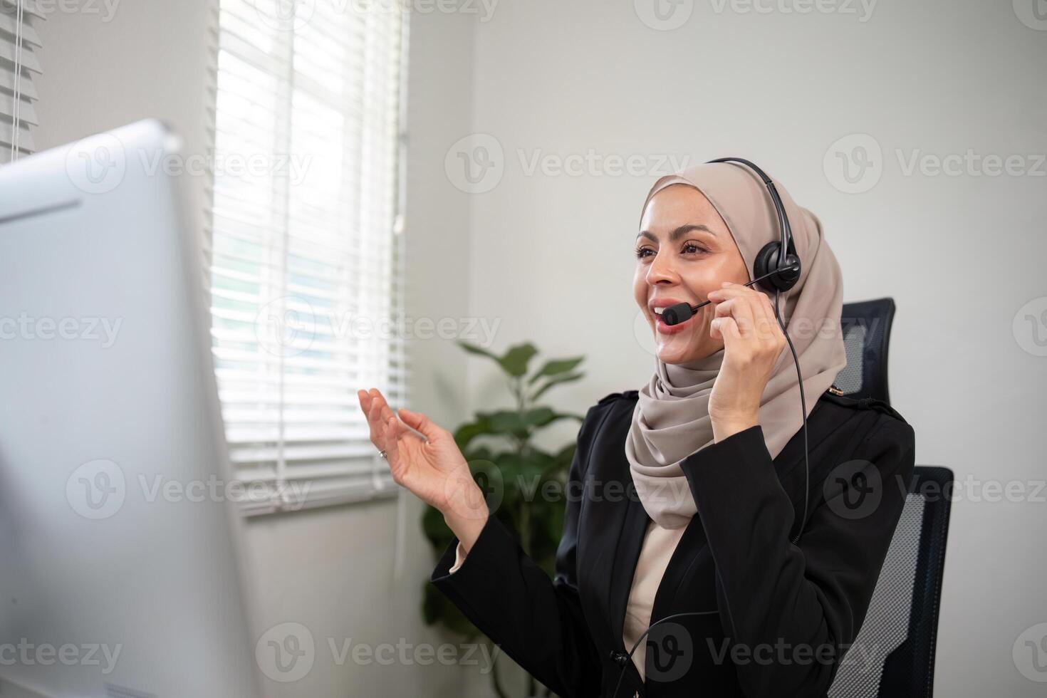 Young muslim women wearing hijab telemarketing or call center agent with headset working on support hotline at office photo