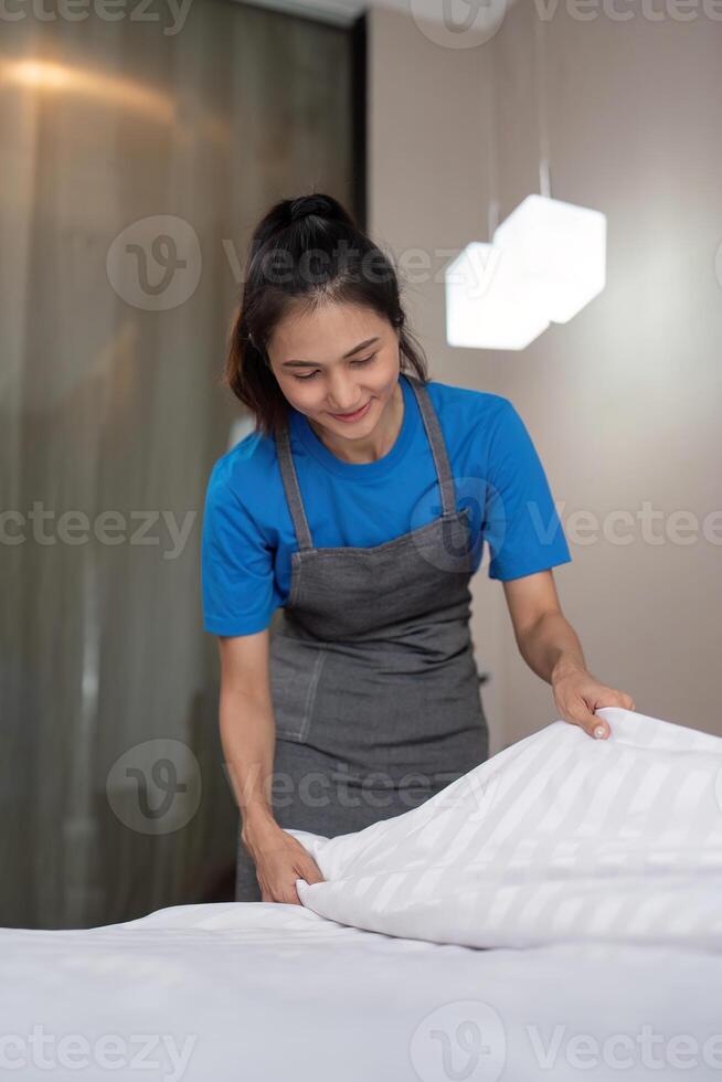 A woman asian staff cleaning service, tool and bucket for work. a young female cleaner with products to clean a bedroom photo