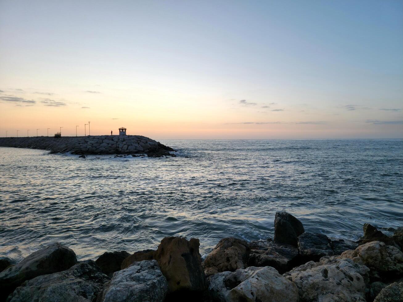 interminable ver de Oceano con rocas en el puesta de sol foto