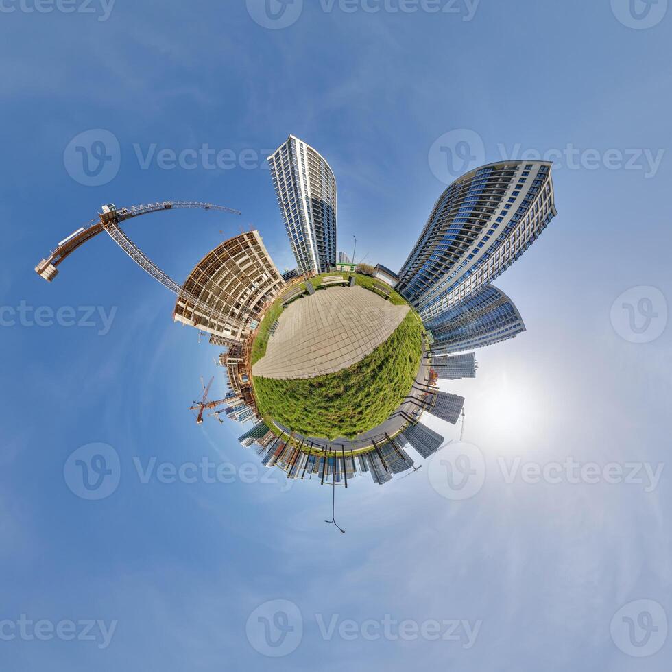 abstract swirling tiny planet spherical panorama of multi-storey buildings of skyscrapers of a residential complex in the form of a butterfly in blue sky photo