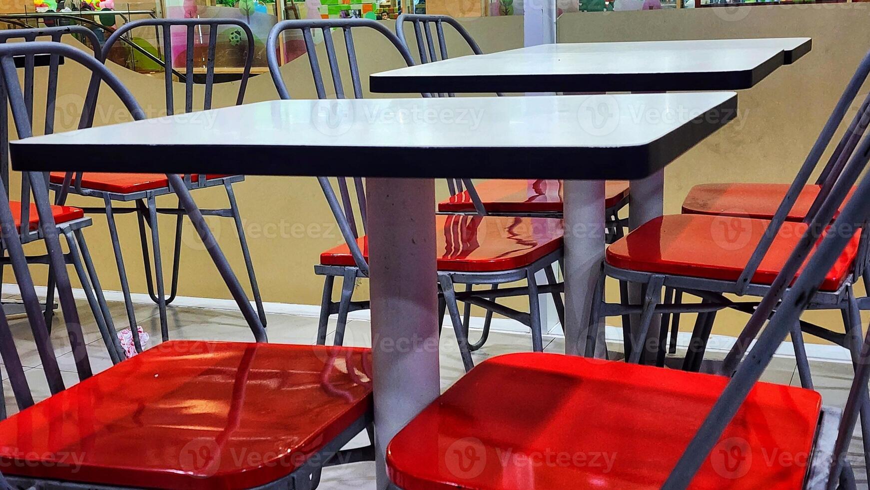 a table with red and white chairs in a restaurant photo