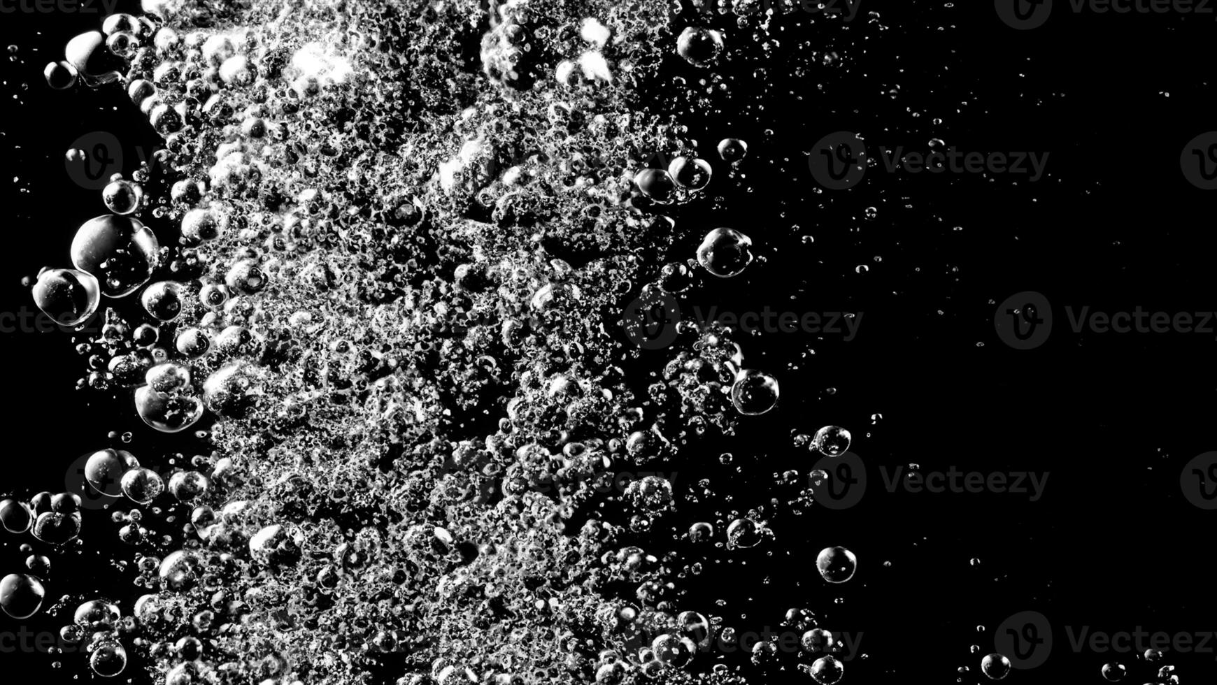 Soda water bubbles splashing underwater against black background. photo