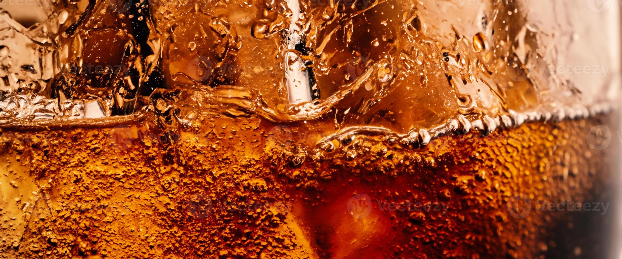 Splashing of Cola and Ice. Cola soda and ice splashing fizzing or floating up to top of surface. Close up of ice in cola water. Texture of carbonate drink with bubbles in glass. Cold drink background photo