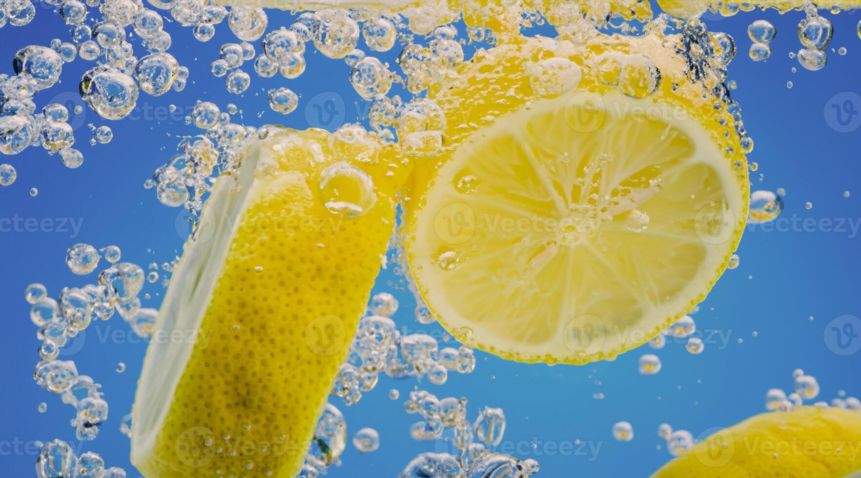 Underwater lemon slice in soda water or lemonade with bubbles. photo