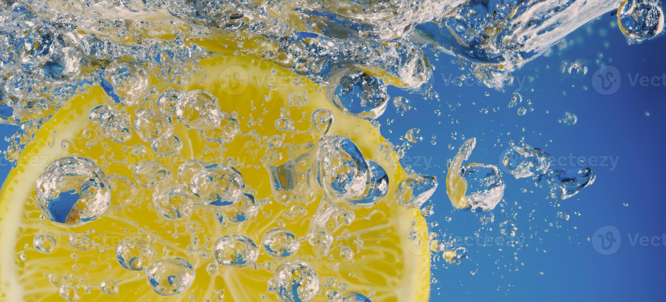 Underwater lemon slice in soda water or lemonade with bubbles. photo