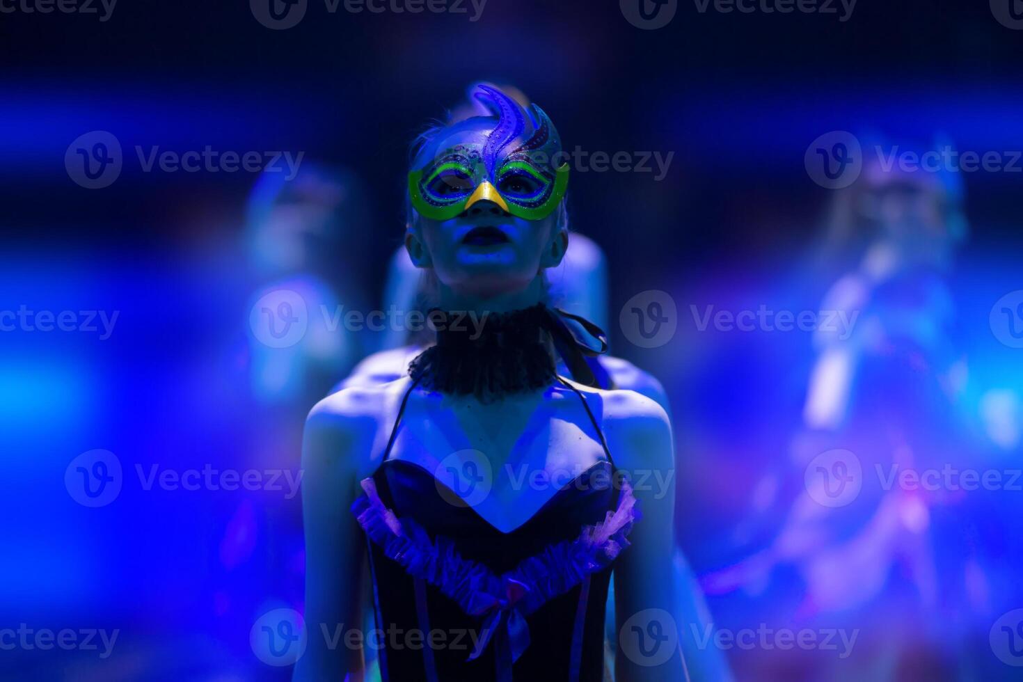 A girl dances in a show or circus in the blue rays of stage lighting. Theatrical performance. photo