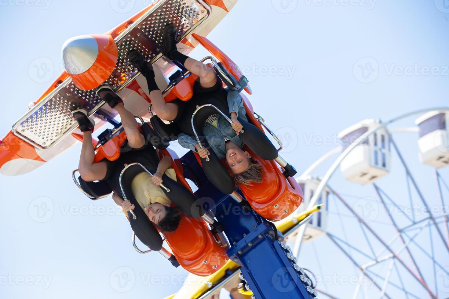 Teenagers ride head down on a carousel. Extreme rides in the park. photo