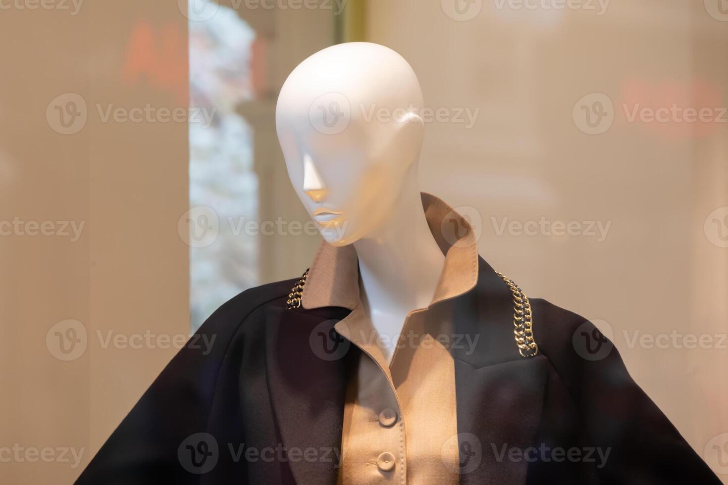 Female mannequin in a store window wearing elegant classic clothes. photo