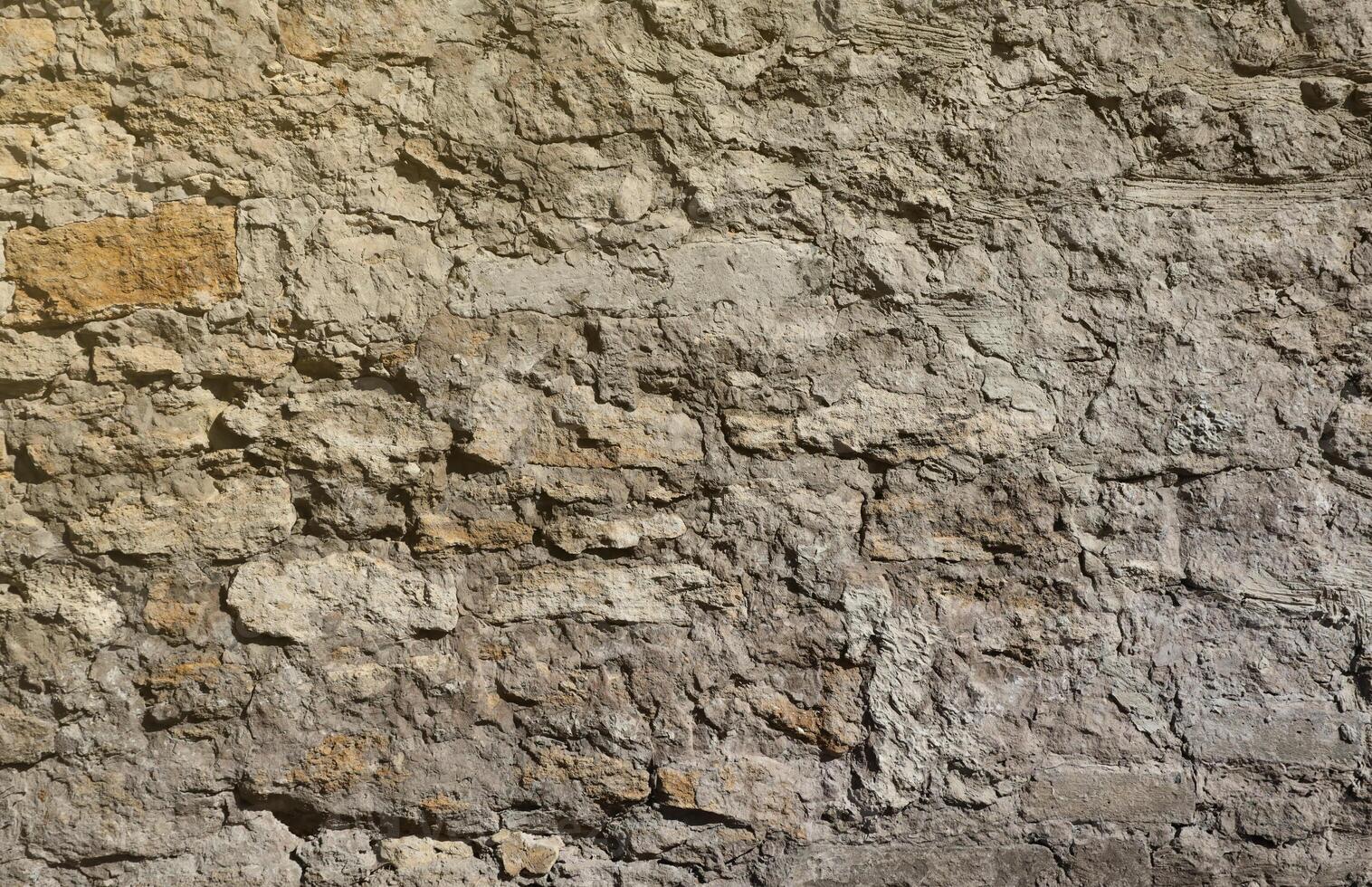 Very old brick stone wall of castle or fortress of 18th century. Full frame wall with obsolete dirty and cracked bricks photo